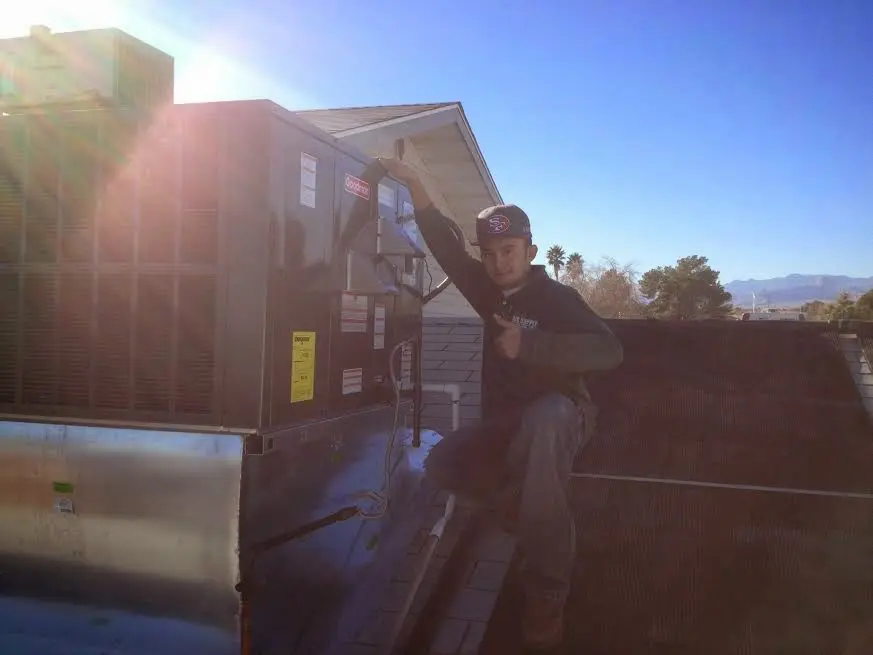 HVAC technician performing AC Tune-Up on a rooftop unit in Chanute